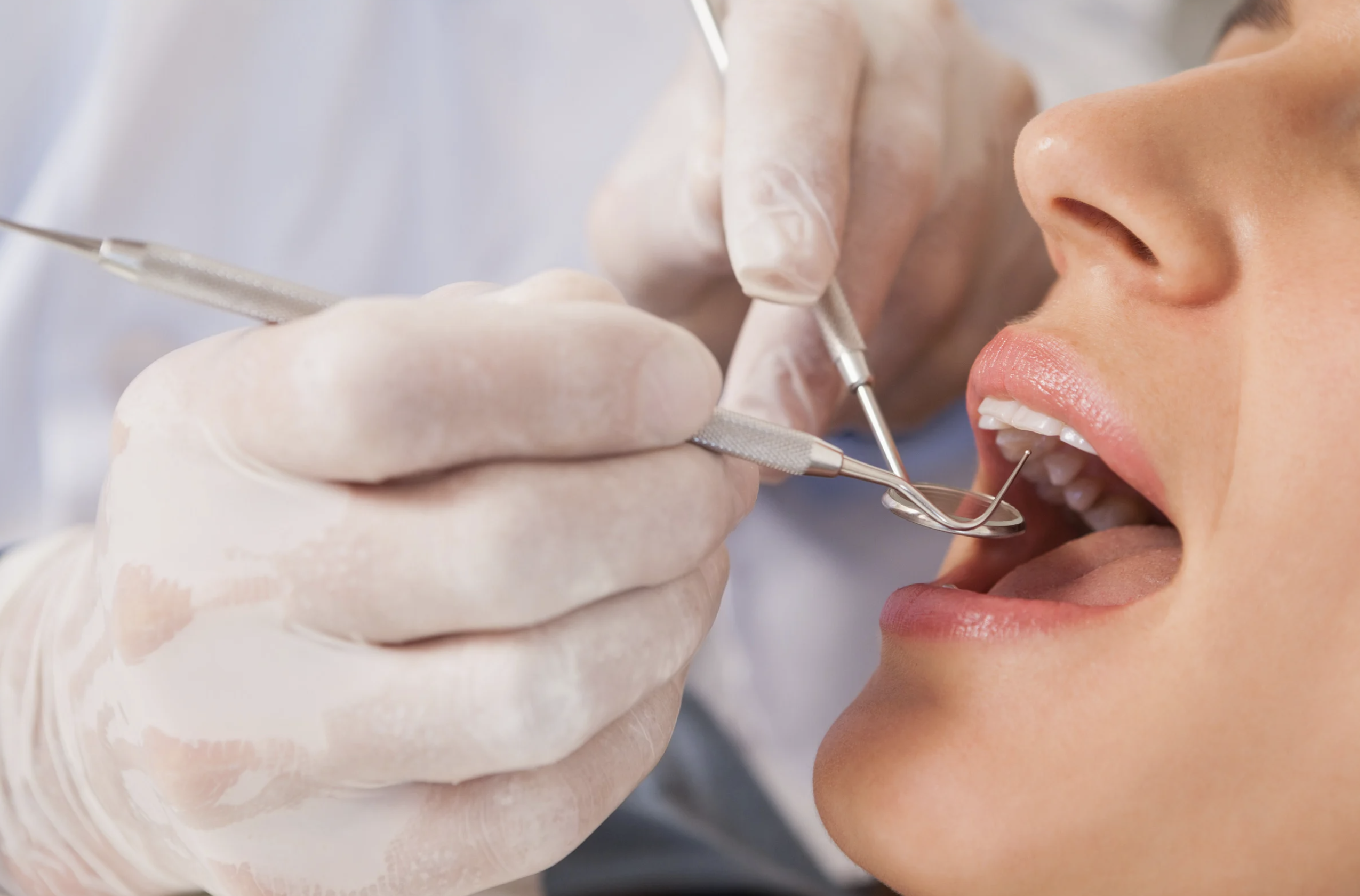 A dentist examines a patient’s teeth