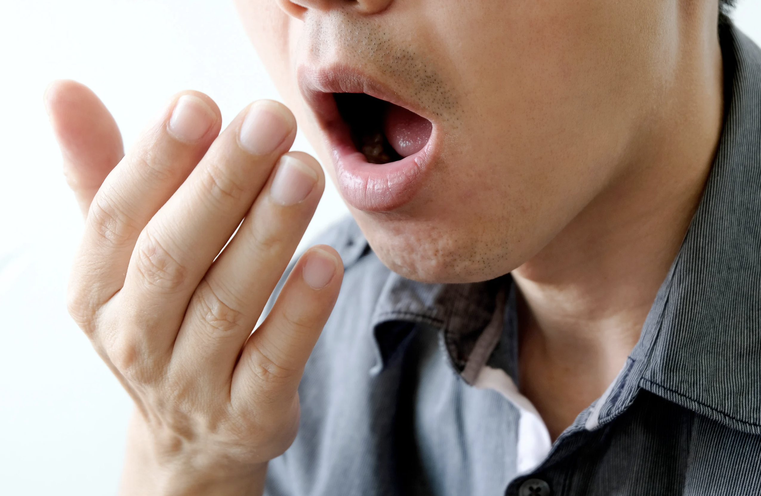 A man checks himself for bad breath.